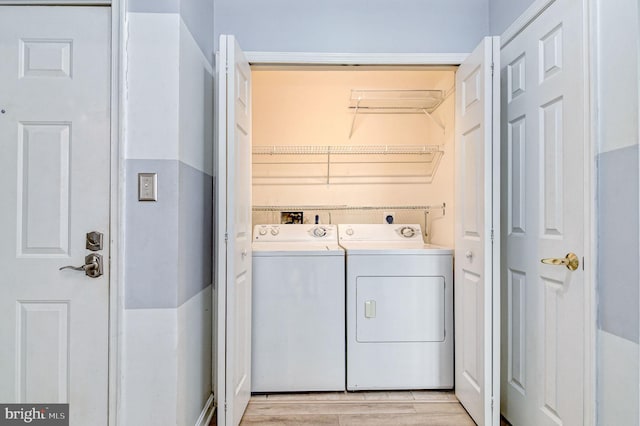 washroom with light hardwood / wood-style floors and separate washer and dryer