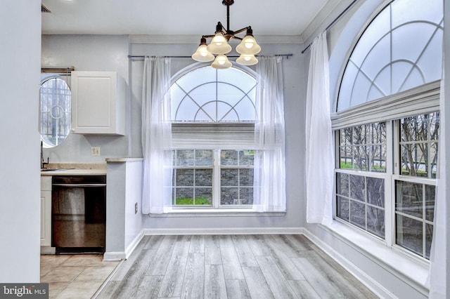 interior space featuring a notable chandelier, light hardwood / wood-style flooring, and ornamental molding