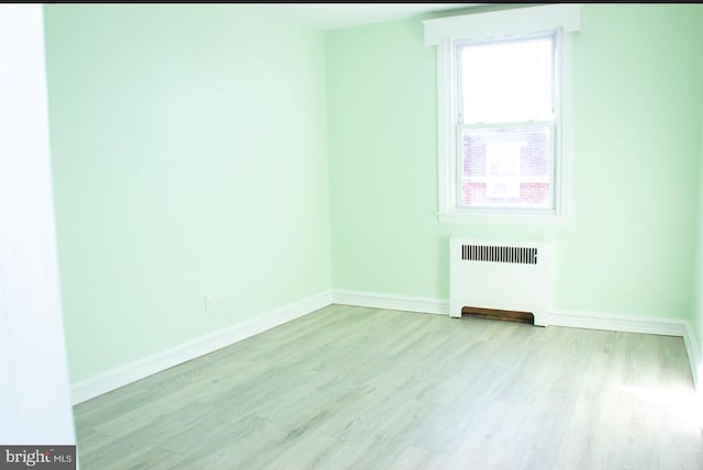 unfurnished room with radiator and light hardwood / wood-style floors