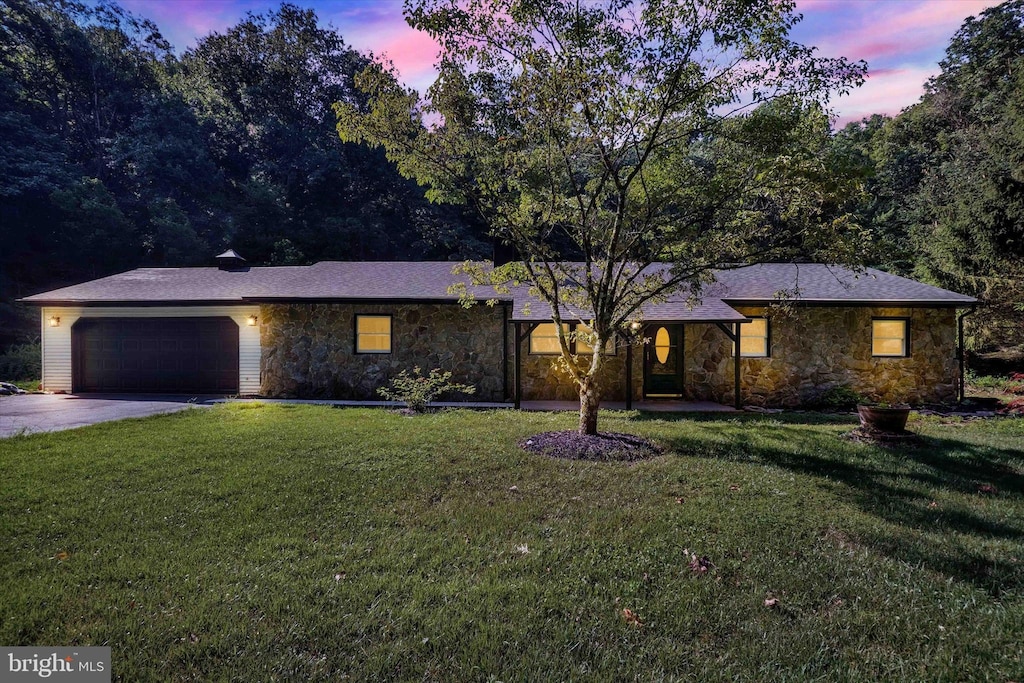 ranch-style house with a yard and a garage