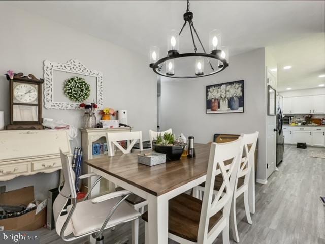 dining space featuring light hardwood / wood-style flooring and a chandelier