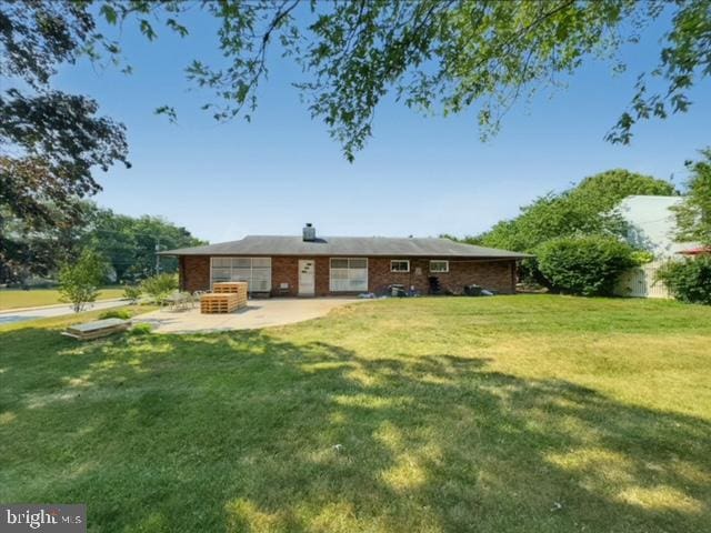 rear view of house featuring a patio and a yard