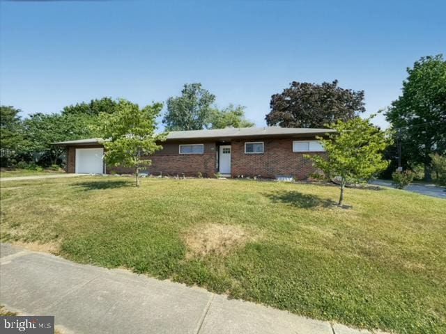 ranch-style house featuring a garage and a front lawn