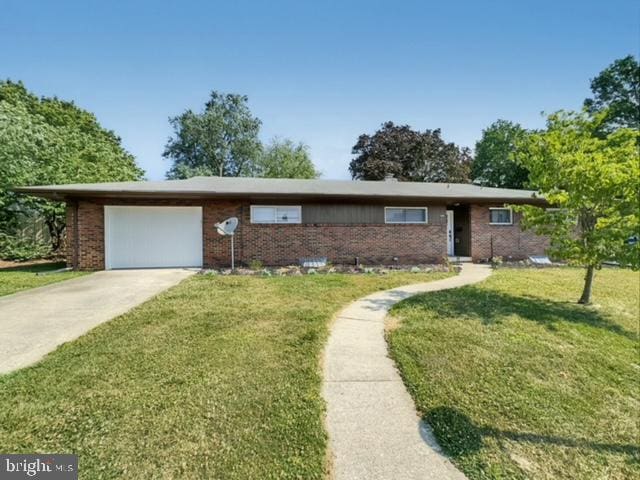 ranch-style home with a garage and a front yard