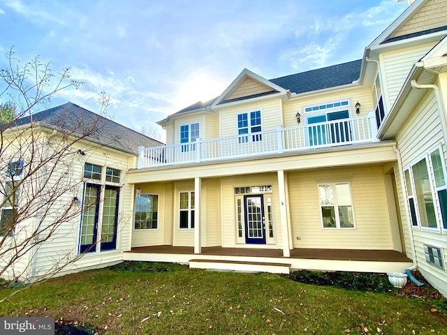 back of house featuring a yard and a balcony