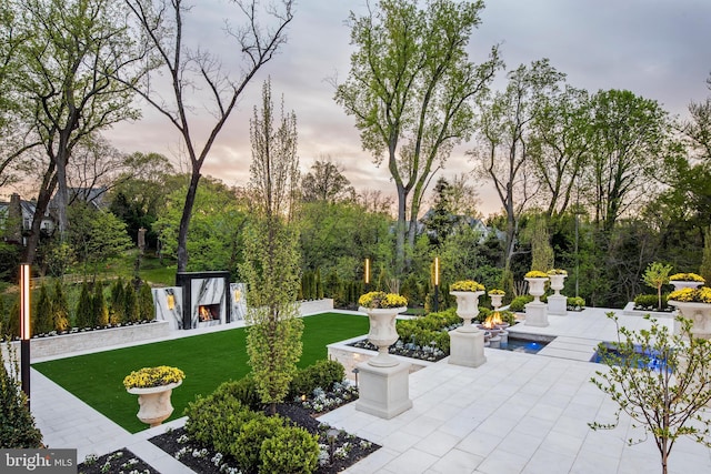 view of community featuring a pool, a yard, and a patio