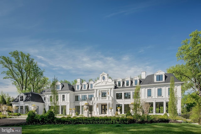 view of front of house with a balcony and a front yard