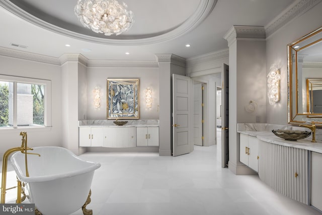 bathroom featuring a raised ceiling, a tub, vanity, and ornamental molding