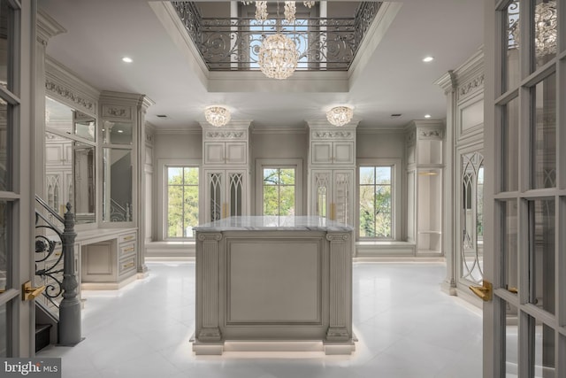 spacious closet with a raised ceiling, french doors, and a chandelier