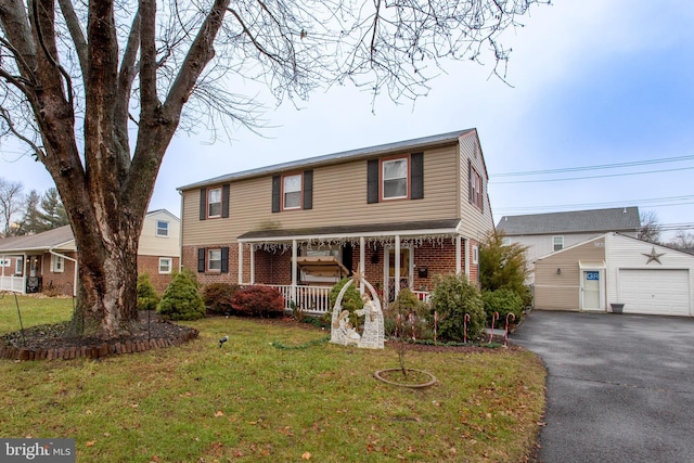 view of front of home featuring an outdoor structure, a front lawn, a porch, and a garage