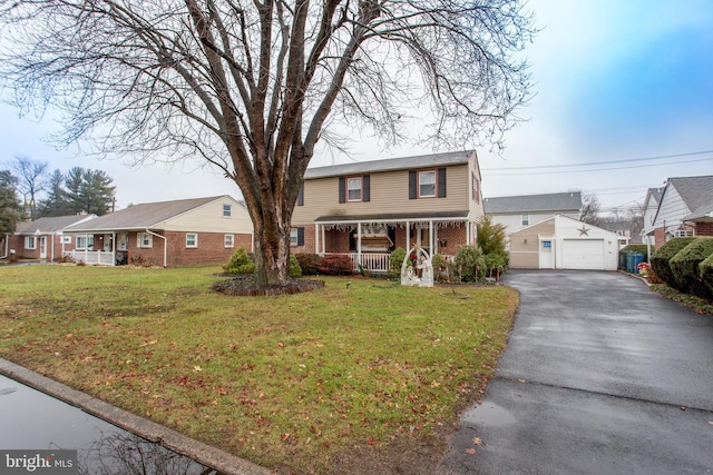 view of property featuring a garage, covered porch, an outbuilding, and a front yard