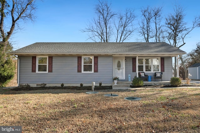 ranch-style house featuring covered porch and a front lawn