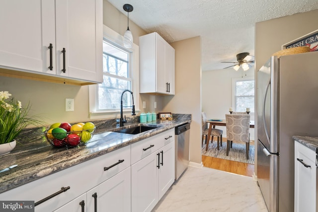 kitchen with dark stone countertops, sink, stainless steel appliances, a textured ceiling, and white cabinets