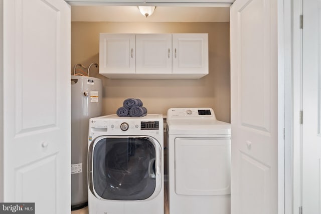 clothes washing area with water heater, separate washer and dryer, and cabinets