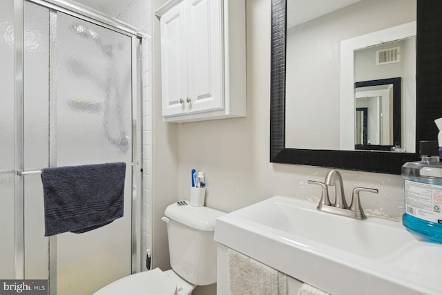 bathroom featuring toilet, an enclosed shower, and sink