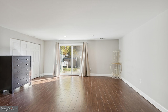 interior space with access to exterior, a closet, and dark hardwood / wood-style flooring