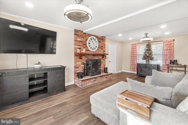 living room featuring hardwood / wood-style floors, a brick fireplace, and ornamental molding