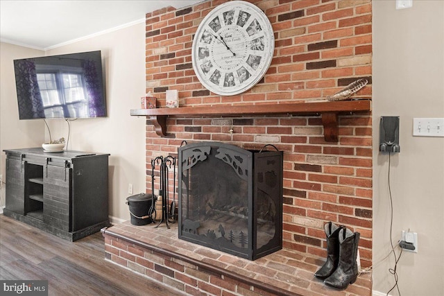 details featuring hardwood / wood-style flooring, a brick fireplace, and ornamental molding