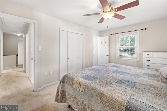 bedroom with ceiling fan, light colored carpet, and a closet