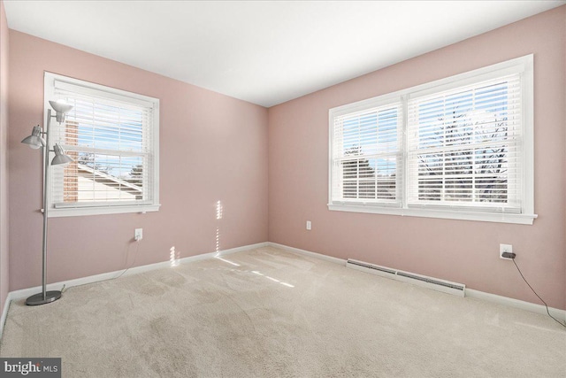 carpeted empty room with plenty of natural light and a baseboard heating unit