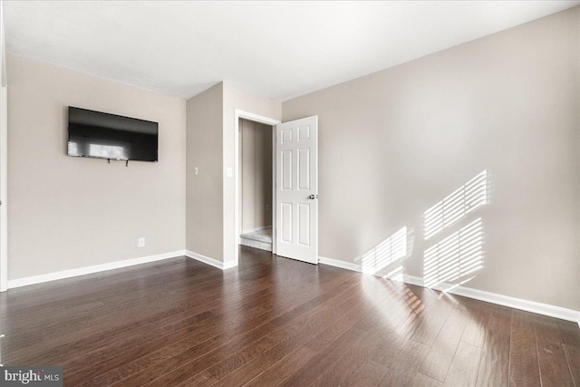 spare room with dark wood-type flooring