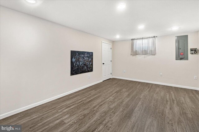 basement with electric panel and dark hardwood / wood-style floors