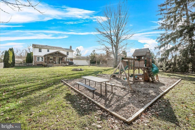 view of playground with an outdoor fire pit and a lawn