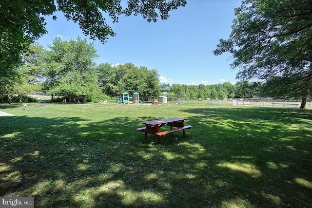 view of property's community with a playground and a yard