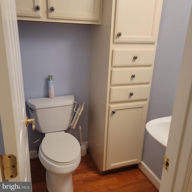 bathroom featuring hardwood / wood-style flooring and toilet