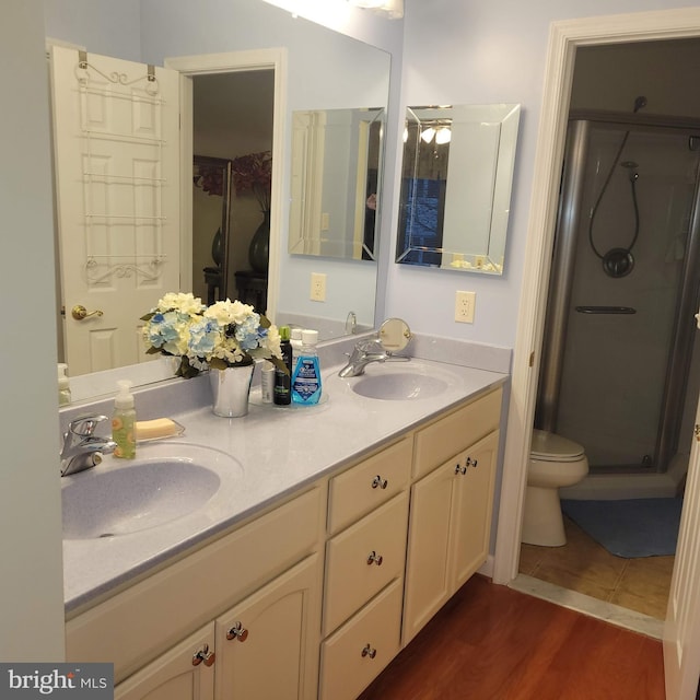 bathroom with hardwood / wood-style flooring, vanity, toilet, and walk in shower