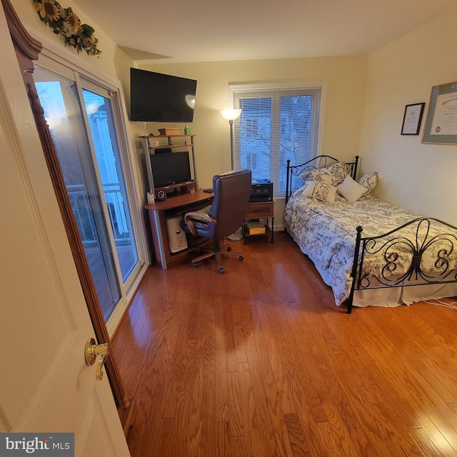 bedroom with access to outside and hardwood / wood-style floors