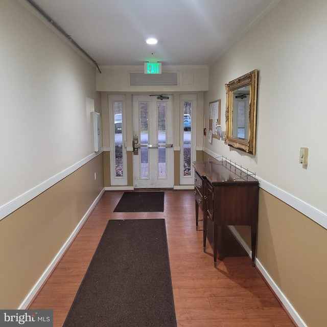 doorway to outside with wood-type flooring and ornamental molding