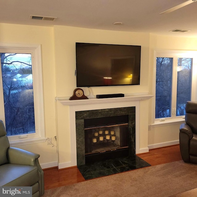 sitting room with dark wood-type flooring and a high end fireplace