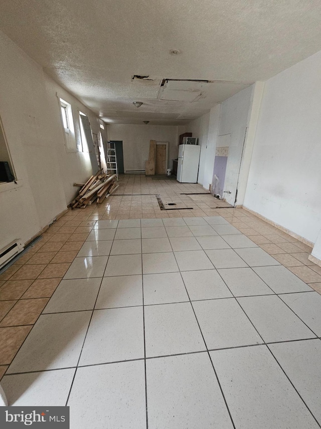 tiled empty room with a textured ceiling