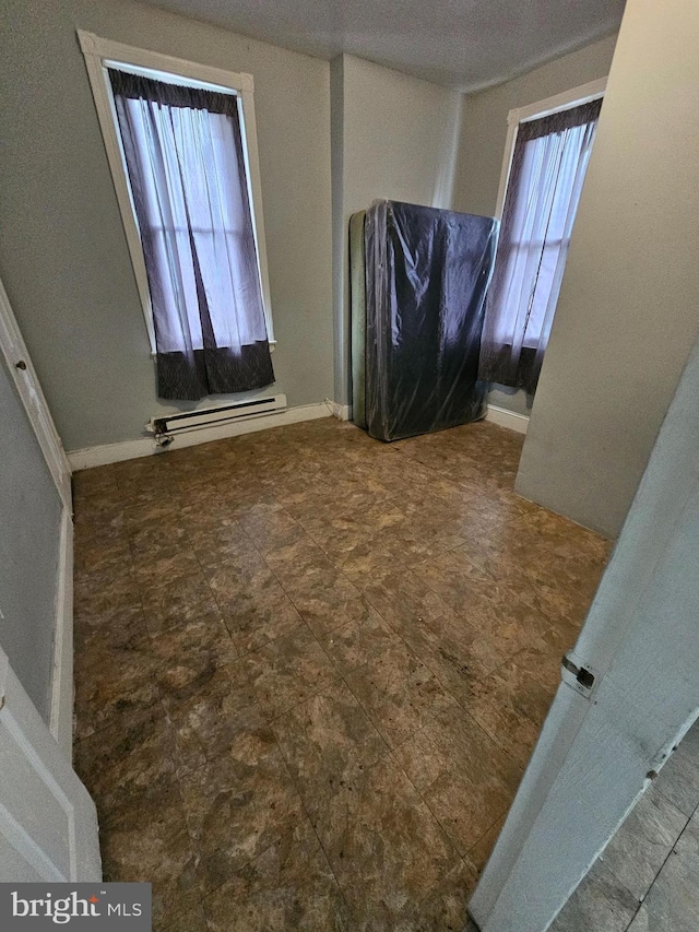 interior space with a wealth of natural light and a baseboard heating unit