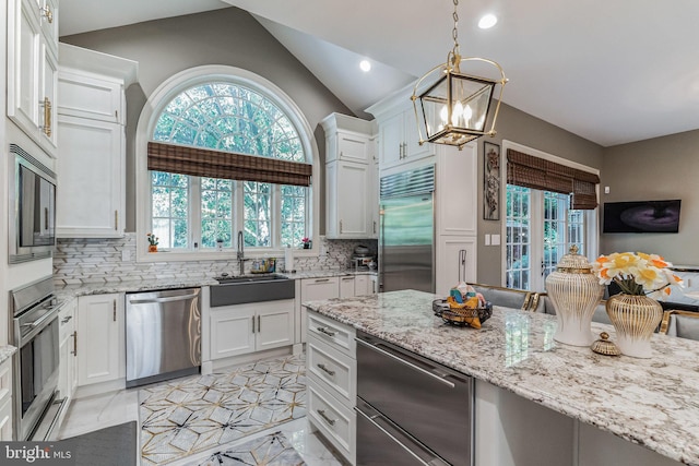 kitchen featuring white cabinetry, built in appliances, decorative backsplash, and sink