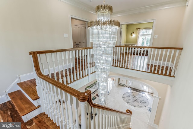 stairway featuring hardwood / wood-style flooring, crown molding, and a notable chandelier