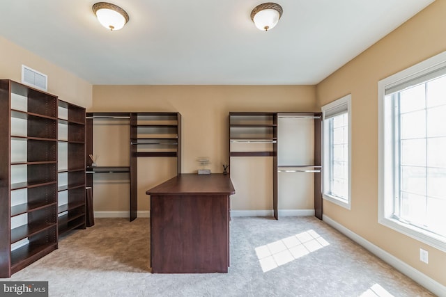 spacious closet featuring light colored carpet