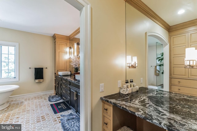 bathroom featuring crown molding, vanity, and a bath