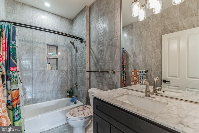 full bathroom with vanity, shower / tub combo with curtain, tile walls, a notable chandelier, and toilet