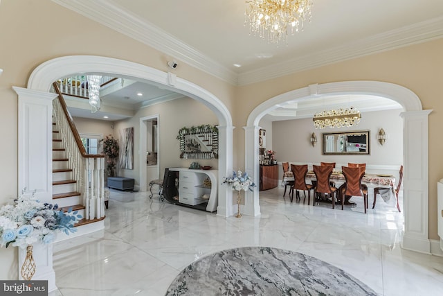 entryway with crown molding and an inviting chandelier