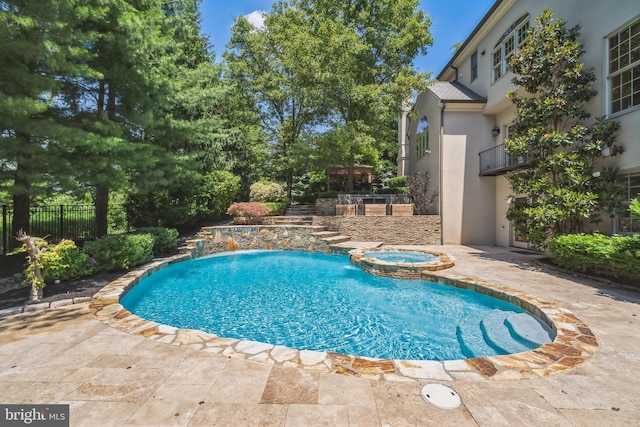 view of pool with an in ground hot tub, a patio, and pool water feature