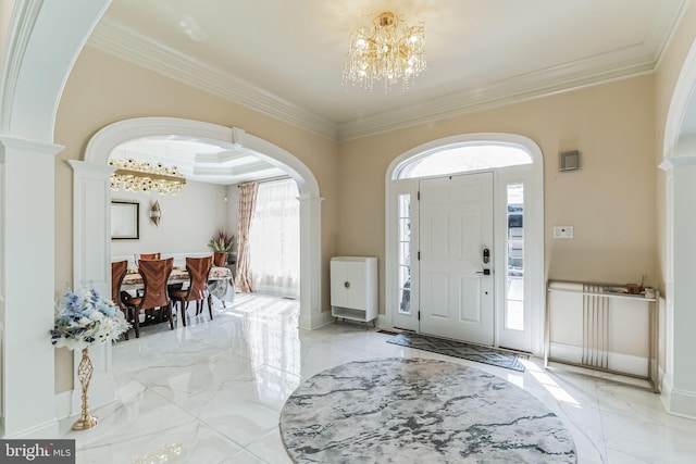 foyer entrance featuring a raised ceiling, a chandelier, and ornamental molding