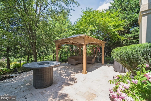 view of patio / terrace featuring a gazebo, cooling unit, and an outdoor living space with a fire pit