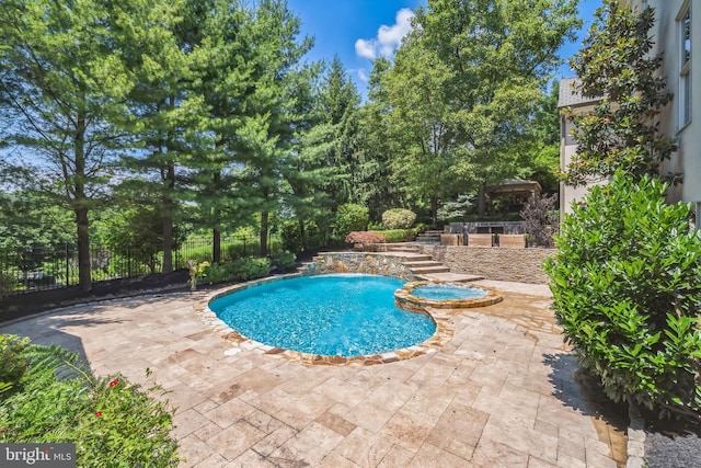 view of swimming pool with an in ground hot tub and a patio area