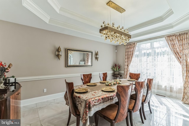 dining area with a chandelier, a raised ceiling, and crown molding