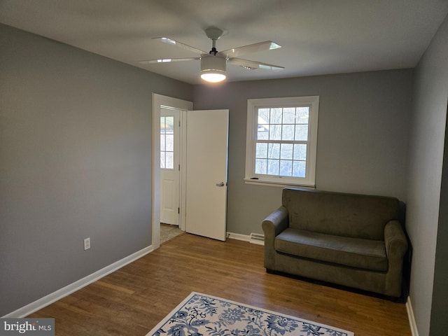 sitting room with ceiling fan and light wood-type flooring