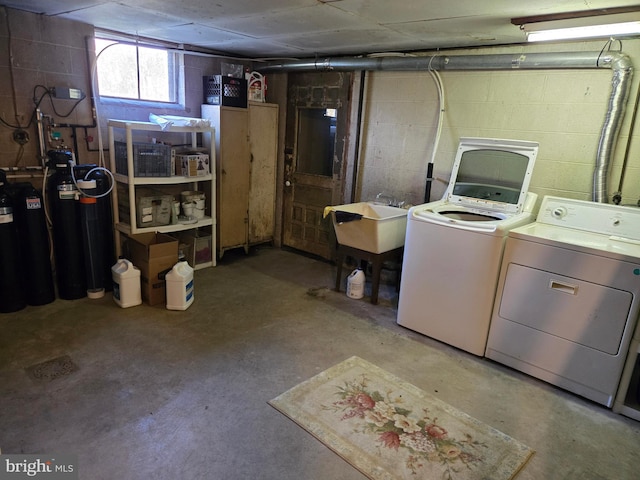 basement featuring separate washer and dryer and sink