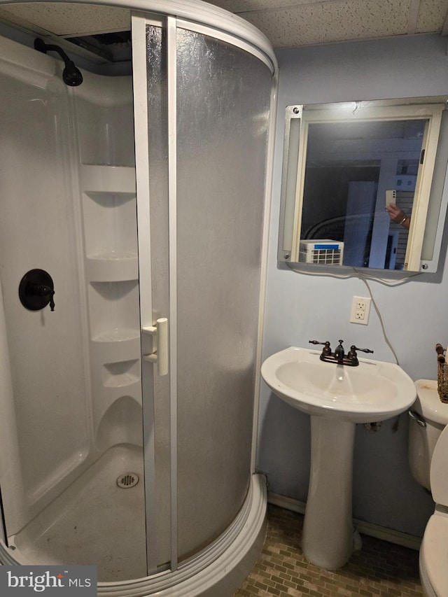 bathroom featuring toilet and a shower with shower door