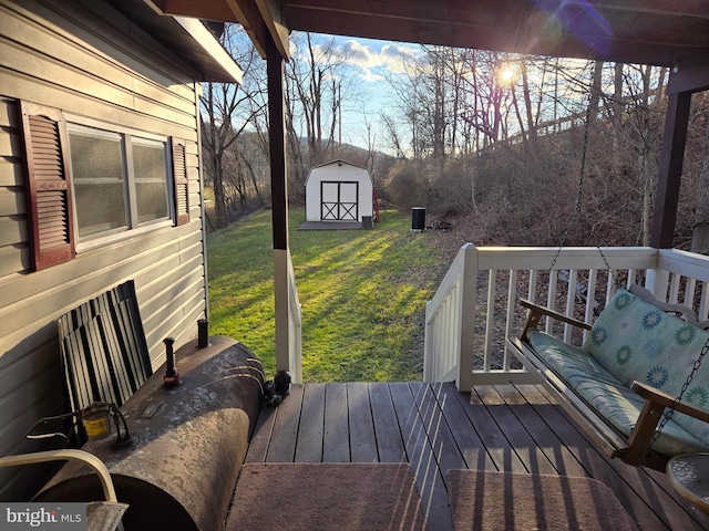 wooden terrace featuring a yard and a storage shed